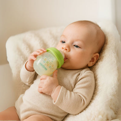 Bébé nourri avec un biberon pour nouveau-né vert à tétine physiologique et débit lent.