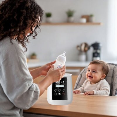 Maman préparant un biberon chaud à l’aide du chauffe biberon multifonction, bébé souriant dans sa chaise haute.