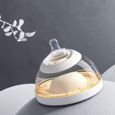 Biberon en forme de sein couleur blanc crĂšme, vu de profil sur fond clair.