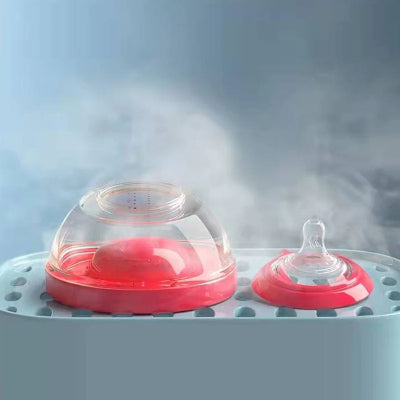 Biberon en forme de sein en cours de stérilisation vapeur, démonté en deux parties.
