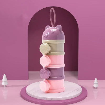 Boite doseuse lait empilable avec quatre compartiments pastel et bouchon ourson, présentée sur fond rose, idéale pour les jeunes parents.
