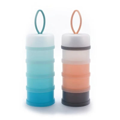 Boites doseuses lait DosiLait™ en coloris bleu et rose pêche, avec anse intégrée et compartiments empilables pour organiser les repas bébé sans stress.