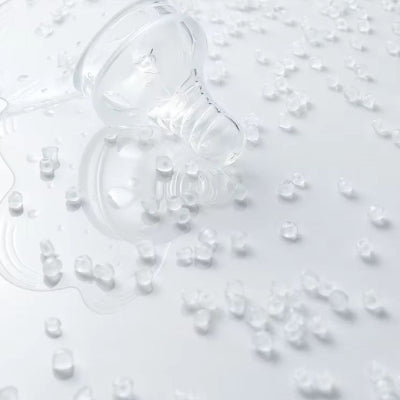 Bout de seins en silicone transparent entouré de granules alimentaires, illustrant la qualité médicale du matériau sans BPA.
