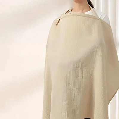 Cape d’allaitement beige portée par une maman, couvrant la poitrine pour allaiter bébé en toute intimité, tissu doux et opaque, idéal pour allaitement discret.