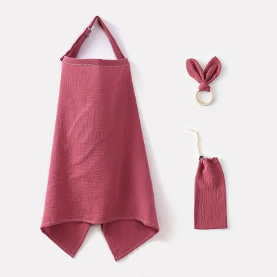 Cape d’allaitement rose framboise avec jouet de dentition et sac assorti, pour des tétées sereines à l’extérieur.