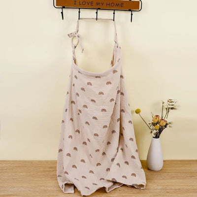Cape d’allaitement Voilâme™ beige avec motifs mini arcs brun chocolat, parfaite pour créer un cocon d’intimité pendant l’allaitement.