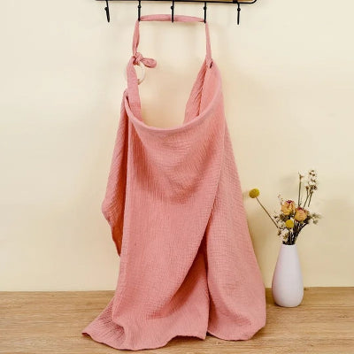 Cape d’allaitement Voilâme™ rose poudré unie, en mousseline douce et respirante, alliant style épuré et fonctionnalité.