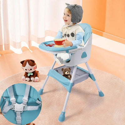Gros plan sur le harnais de sécurité 5 points d’une chaise haute bébé pliable turquoise, bébé installé avec ses jouets à proximité.