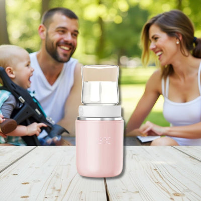 Chauffe biberon portable BabyWarm Pro™ posé sur une table lors d’un pique-nique familial, idéal pour chauffer le lait de bébé en extérieur
