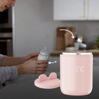 Chauffe biberon rose BabyWarm Pro™ utilisé pour préparer un biberon de lait, avec couvercle détaché en évidence sur le plan de travail