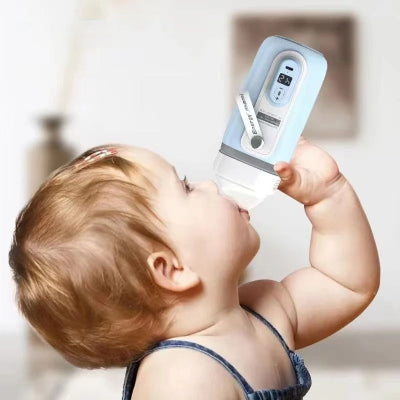 Bébé utilisant le chauffe-biberon nomade pour boire son lait chaud de façon autonome, sécurité et confort assurés