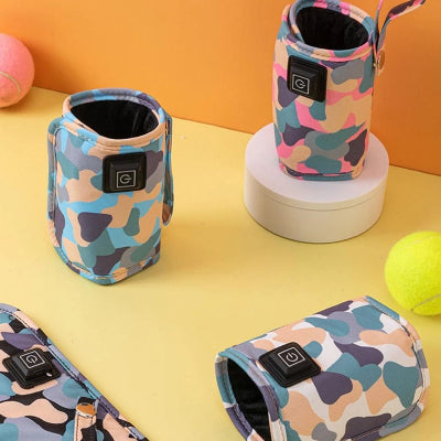 Trois chauffe biberons nomades posés sur un fond jaune avec motif camouflage multicolore, soulignant leur compacité, légèreté et adaptabilité au quotidien des parents.