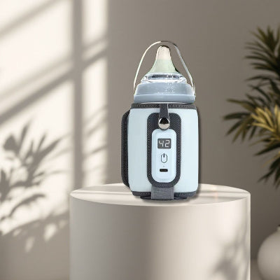 Chauffe biberon nomade blanc sur piédestal dans un environnement lumineux, mettant en avant son design élégant et sa finition soignée.