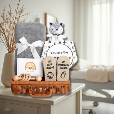 Coffret Naissance Bébé disposé sur une table de chevet dans une chambre de maternité, prêt à être offert après la naissance pour souhaiter la bienvenue au nouveau-né.