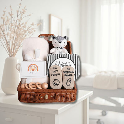 Coffret naissance bébé Toudou™ posé sur une table de chevet dans une chambre de maternité, parfait comme trousse de naissance pratique et attendrissante pour accueillir bébé.