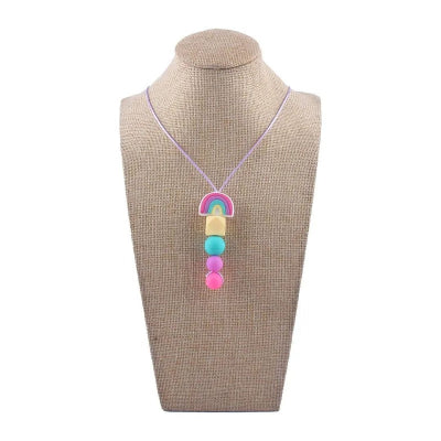 Collier dâallaitement aux couleurs vives arc-en-ciel prĂ©sentĂ© sur buste, bijou de maternitĂ© ludique et apaisant, parfait pour les moments de portage ou dâallaitement actif.