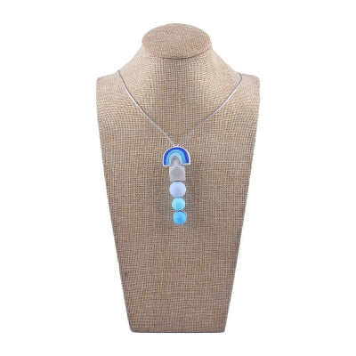 Collier dâallaitement bleu en silicone alimentaire prĂ©sentĂ© sur buste, favorise la motricitĂ© fine, la concentration de bĂ©bĂ© et le soulagement naturel des dents.