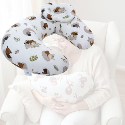 Maman souriante tenant bébé avec un coussin d’allaitement aux motifs animaux, parfait pour des moments de tendresse pendant l’allaitement.