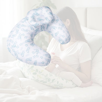 Maman allaitant au lit avec un coussin d’allaitement blanc à motifs feuilles bleues, idéal pour les tétées nocturnes et le confort post-natal.
