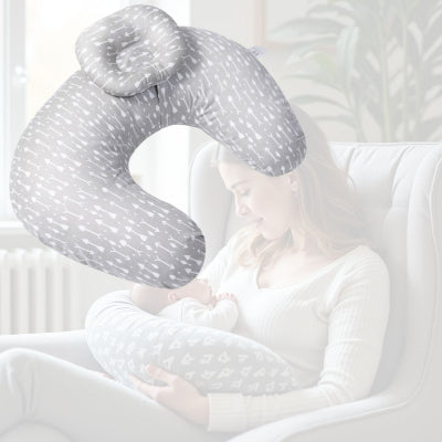 Jeune maman allaitant dans un fauteuil avec coussin d’allaitement gris à flèches, soutien lombaire et position stable pour nourrir bébé en toute sérénité.
