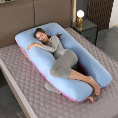 Coussin de grossesse bleu avec rebords roses offrant un soutien lombaire et abdominal pour un sommeil réparateur durant la maternité.