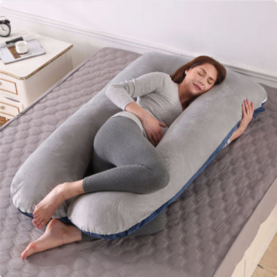 Coussin de grossesse gris en velours moelleux, soulageant le ventre et les hanches pendant la grossesse pour un repos paisible.