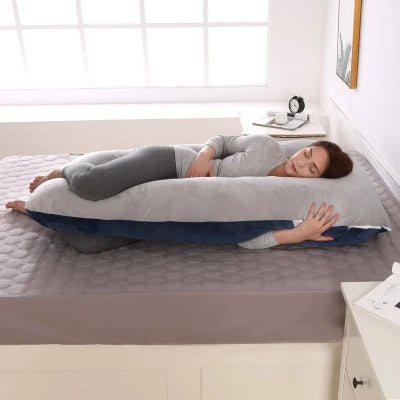Maman allaitant confortablement son bĂ©bĂ© grĂące Ă un coussin de grossesse transformĂ© en coussin dâallaitement polyvalent.