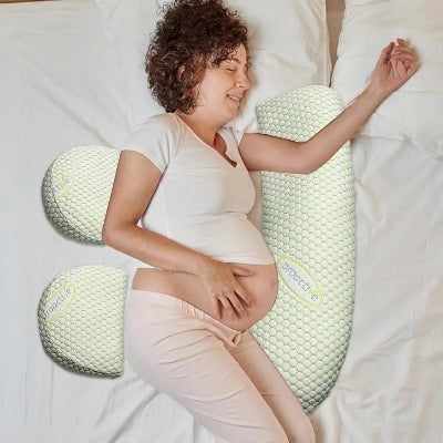 Femme enceinte confortablement allongée avec un coussin de grossesse ergonomique