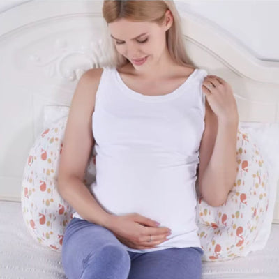 femme enceinte assise avec coussin grossesse pour soutien du dos et du ventre, conçu pour offrir un confort optimal pendant la grossesse