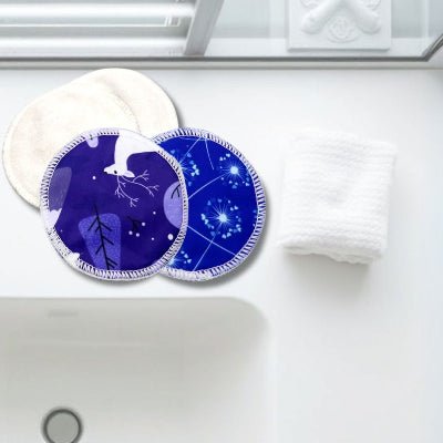 Coussinets d'allaitement CosmicTouch™ en gros plan, posés sur un comptoir de salle de bain minimaliste, alliant style et fonctionnalité.