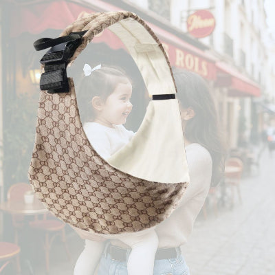 Écharpe de portage au motif marron chic, portée par une maman en balade avec sa fille souriante en ville