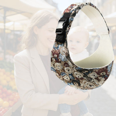 Écharpe de portage originale à motif oursons, utilisée par une maman joyeuse tenant son bébé au marché
