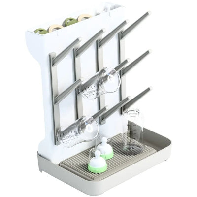 Support de séchage pour biberons et accessoires avec tétines, capuchons et bouteilles sur un égouttoir vertical pratique.
