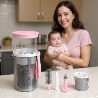 Goupillon biberon electrique TwistBébé rose avec accessoires démontés : brosses silicone, flacon savon et support séchage, utilisé dans une cuisine familiale avec une jeune maman et son bébé.
