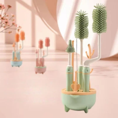 Kit de goupillon biberon complet vert tendre avec base de rangement en forme d’arbre, contenant brosses tétines, pailles et biberons, présenté en intérieur lumineux.