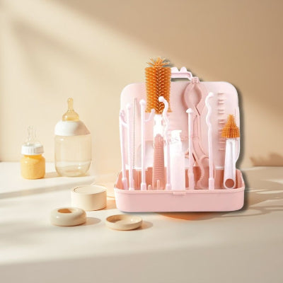Kit goupillon biberon ZenBibiâą rose sur une table ensoleillĂ©e, avec biberons et accessoires dâallaitement prĂȘts Ă ĂȘtre nettoyĂ©s.