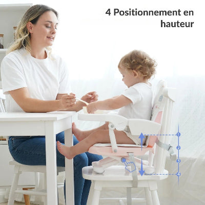 Rehausseur chaise pliable bébé réglable sur 4 hauteurs, installé sur une chaise standard, permettant à l’enfant de manger confortablement à table avec sa maman.