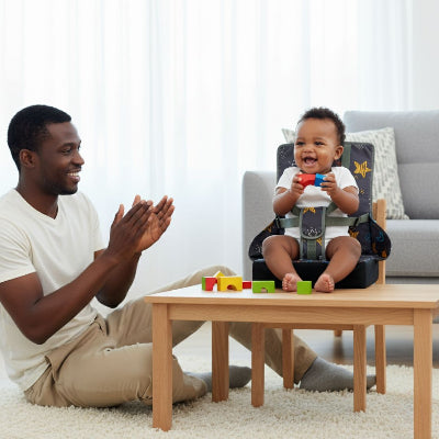 Enfant jouant avec des cubes colorés sur un rehausseur de chaise bébé, coussin surélevateur stable utilisé comme chaise pour bébé table de jeux.