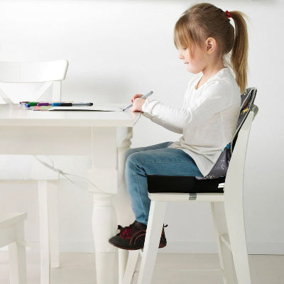 Enfant installé sur un coussin réhausseur bébé, chaise pour enfant table de travail, parfait comme coussin surélevateur évolutif.