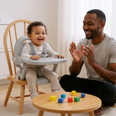 Réhausseur de chaise bébé utilisé à la maison dans la cuisine, maman donne à manger au bébé tandis que papa prépare les légumes.