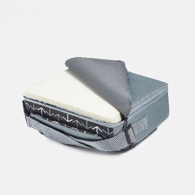 Bébé installé dans un rehausseur de chaise pour bébé bleu marine motif losanges, maman le nourrit à la cuillère dans la salle à manger familiale.