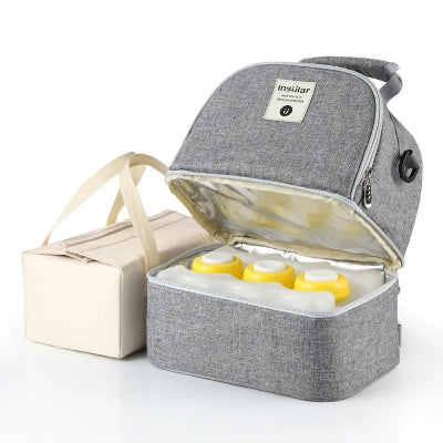 Sac isotherme Bebe gris avec compartiment inférieur contenant 3 biberons et bloc réfrigérant, idéal pour transporter le lait maternel en toute sécurité.