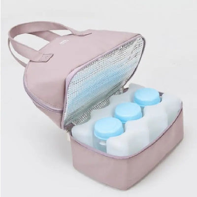 Compartiment inférieur du sac isotherme bébé avec des biberons entourés de blocs réfrigérants pour maintenir la fraîcheur du lait.