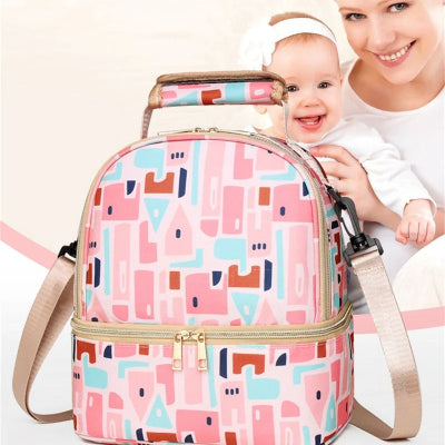 Sac isotherme Bebe motif géométrique présenté avec une maman souriante et son bébé, illustrant un moment de complicité et de praticité en sortie.