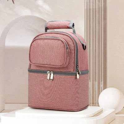 Sac isotherme Bebe rose BibiCool™ avec double compartiment thermique et poignée renforcée, posé dans un décor élégant.