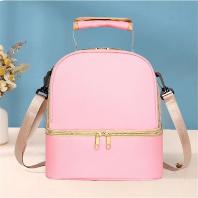Sac isotherme Bebe rose pastel avec design épuré et anse rembourrée, parfait pour les jeunes mamans en quête de style et de praticité.