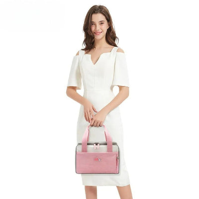 jeune femme élégante tenant un sac isotherme Bebe rose et gris, accessoire pratique et stylé pour le transport du repas de bébé