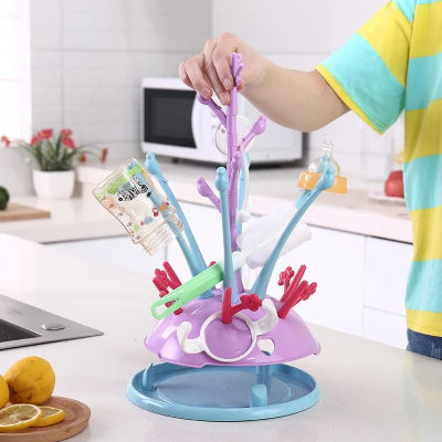 Sèche biberon posé sur un plan de travail de cuisine familiale avec biberons, goupillon et tétines, conçu pour gagner de la place.