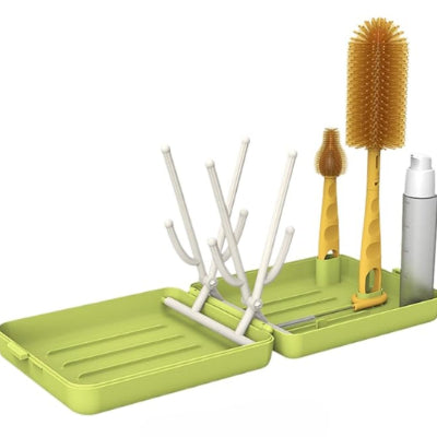 Sèche biberon vert ouvert montrant les colonnes déployées, les brosses et le flacon distributeur rangés proprement.