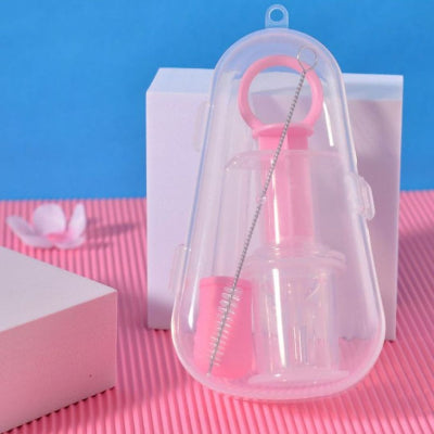 Seringue d'alimentation orale avec tétine rose, incluse dans un boîtier transparent avec un petit pinceau pour un nettoyage facile.